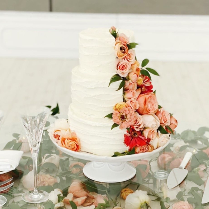 Image of white wedding cake with flowers on the side