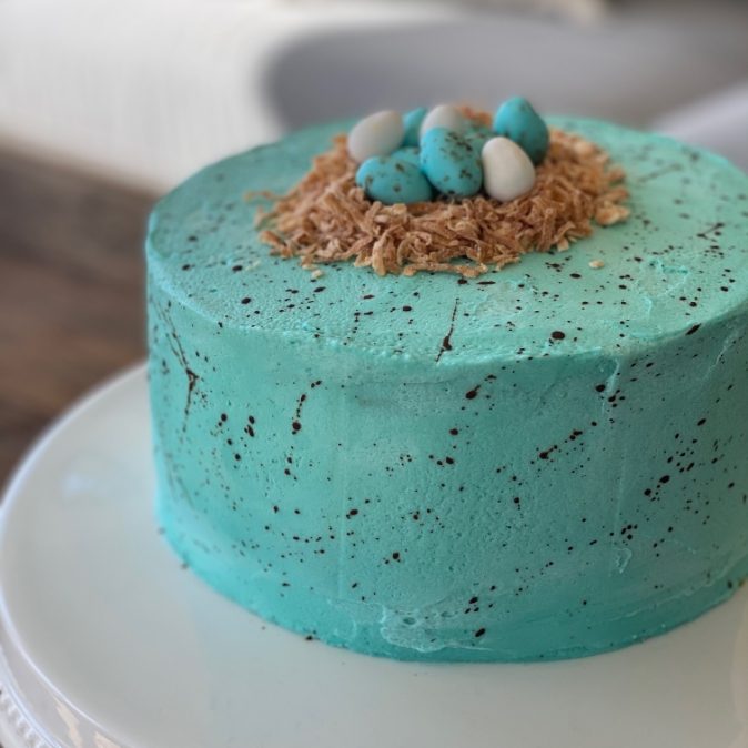 Image of blue cake with birds nest and eggs on top